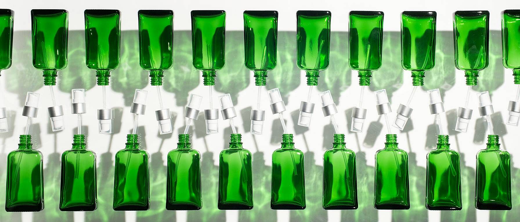 row of green bottles on an assembly line