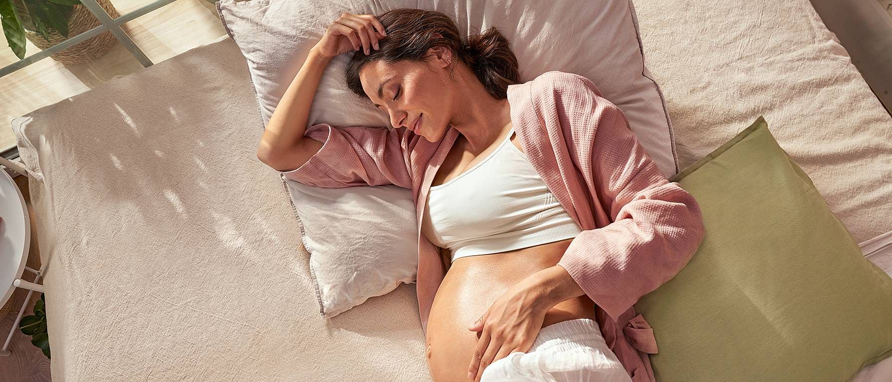pregnant woman laying on bed