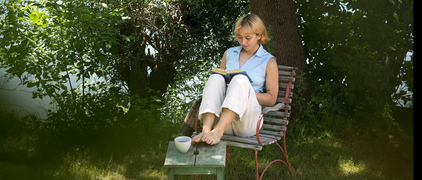 Girl sitting under a tree rading a book