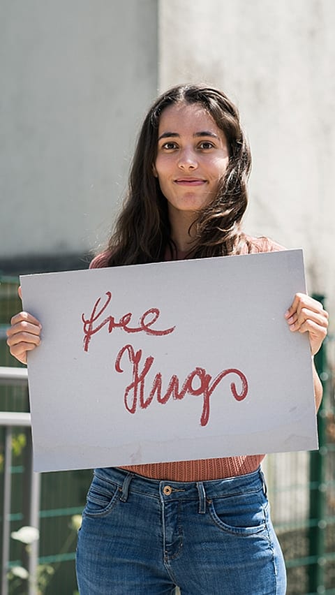 woman holding free hugs sign