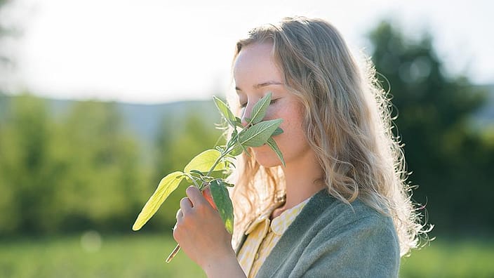 woman smelling a plant
