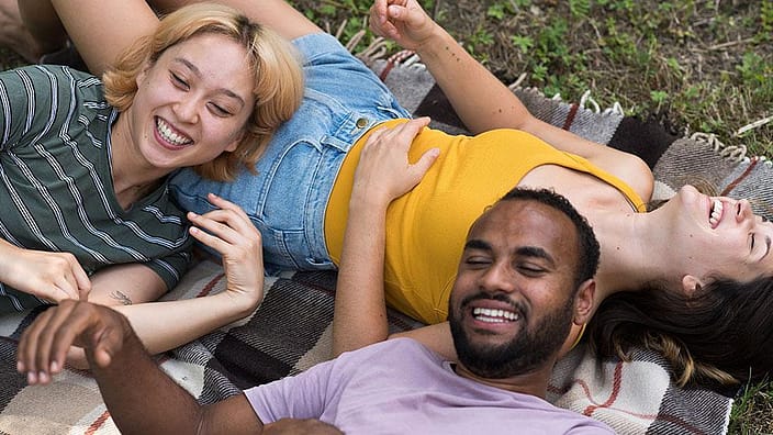 people laughing and laying in grass