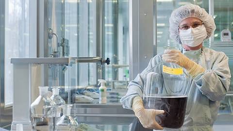 person in lab coat working in laboratory