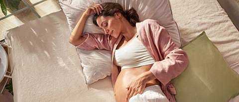 pregnant woman laying on bed