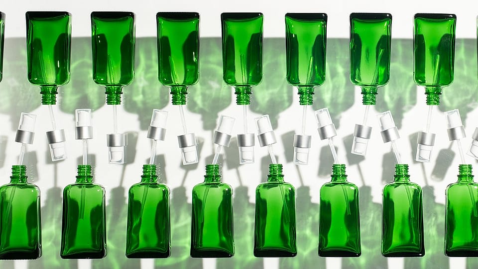row of green bottles on an assembly line