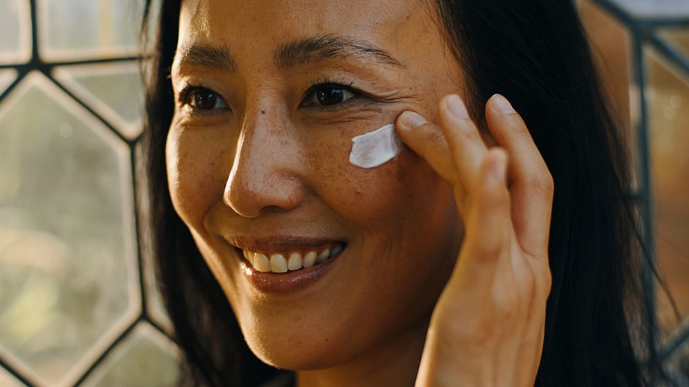 woman applying cream to face