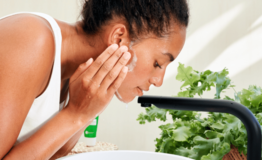 Woman applying face cleanser